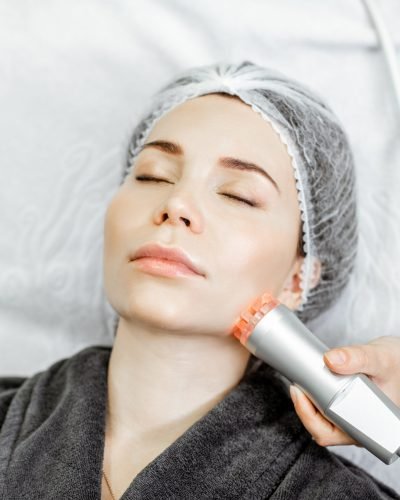 Woman during the oxygen mesotherapy procedure at the beauty salon, close-up view. Concept of a professional facial treatment